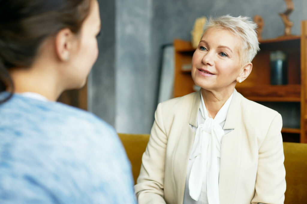 Professional environment.Older woman receiving feedback from subordinate female.