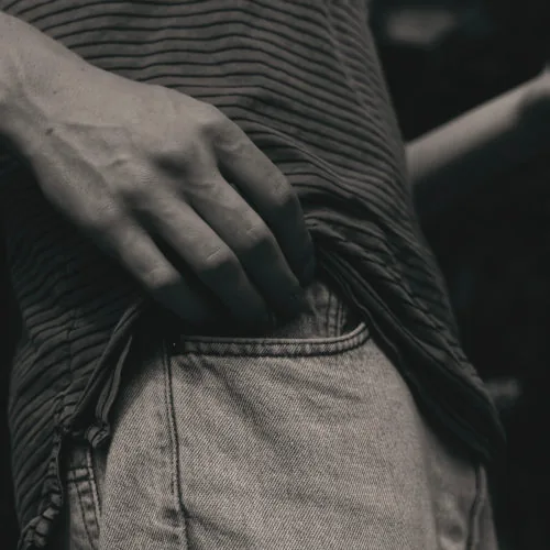 A black and white picture of a hand in a pocket.